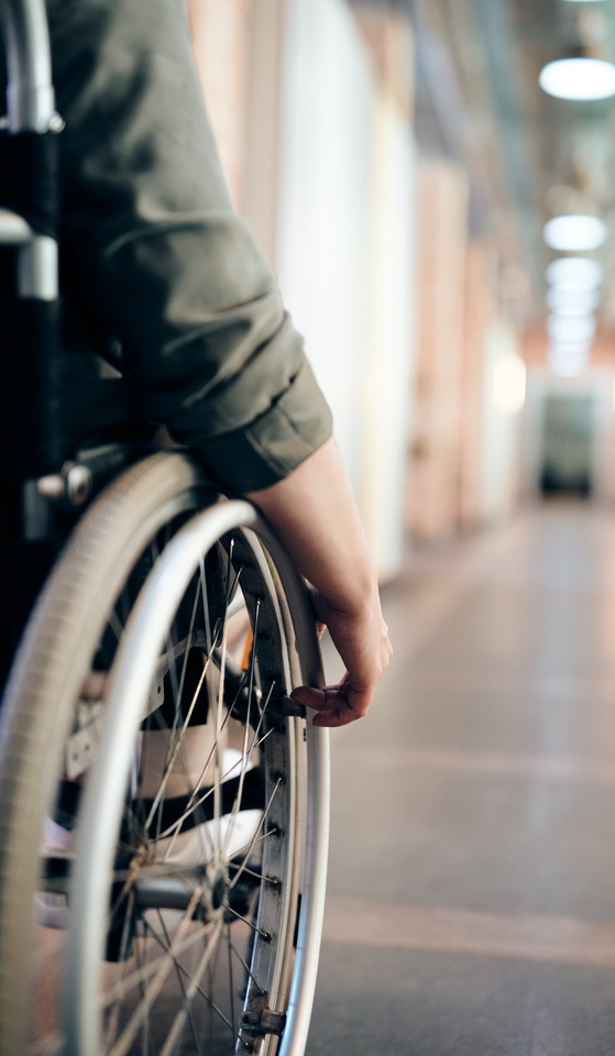 Personne en fauteuil roulant dans le couloir